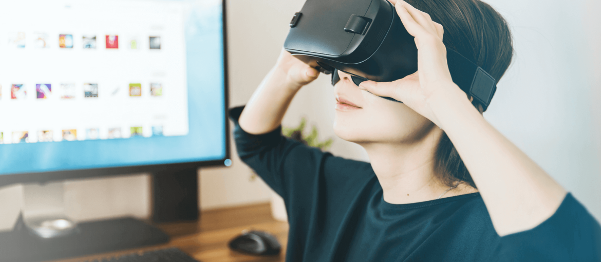 A person wearing a vr headset in front of a computer.