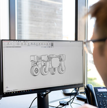 A person looking at a computer screen with drawings on it.