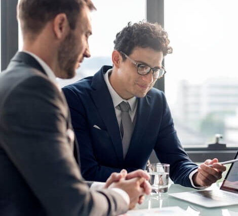 Two men in suits are sitting at a table