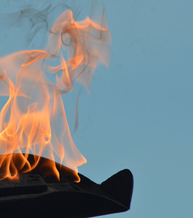 A fire is burning in the sky on top of a building.