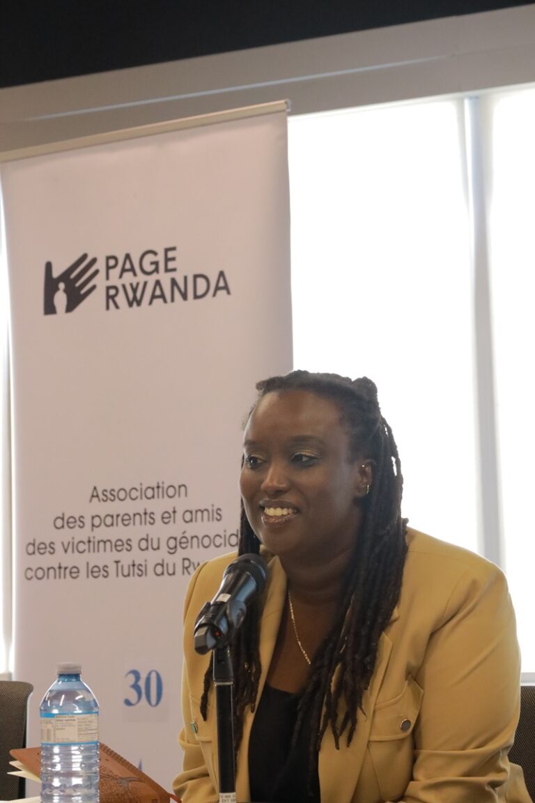 A woman with dreadlocks is speaking at an event.