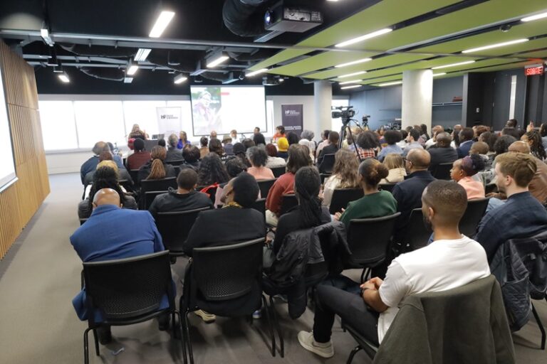 A large group of people sitting in chairs at a presentation.