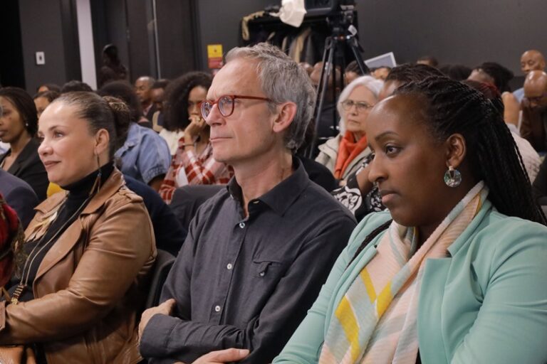 A group of people sitting in front of a camera.