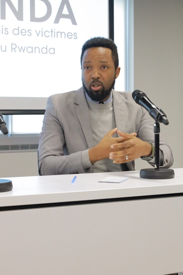 A man sitting at a table with a microphone.