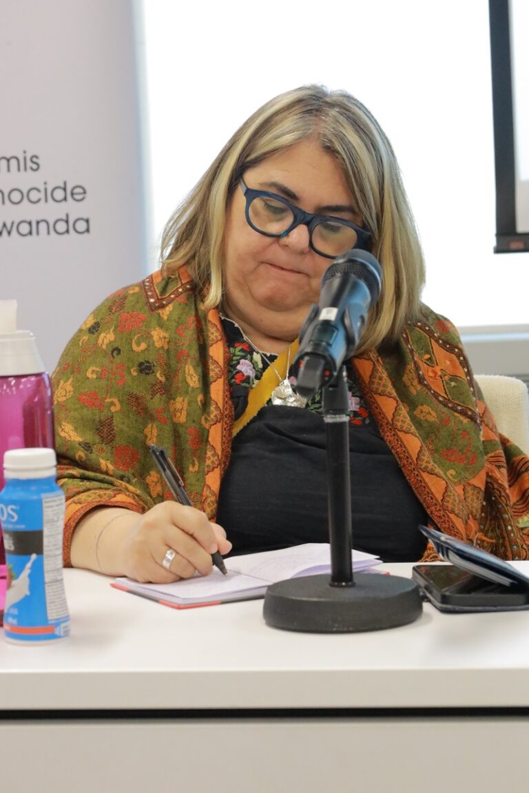 A woman sitting at a table with a microphone.