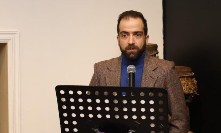 A man in a suit and tie is holding a microphone