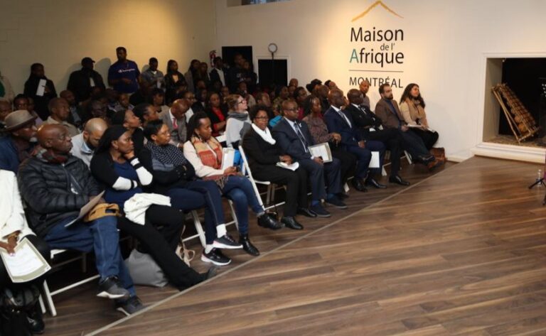 A group of people sitting on chairs in front of a wall.