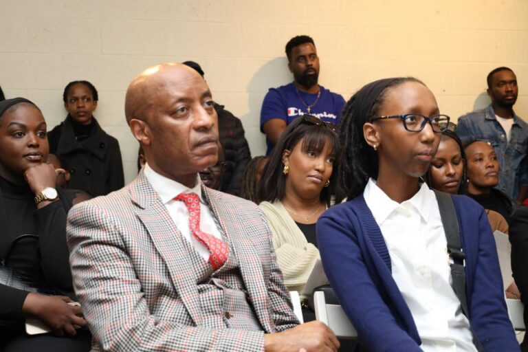 A man and woman sitting in front of other people.