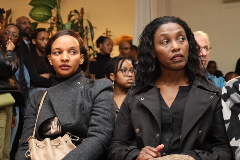 Two women in black jackets sitting next to each other.