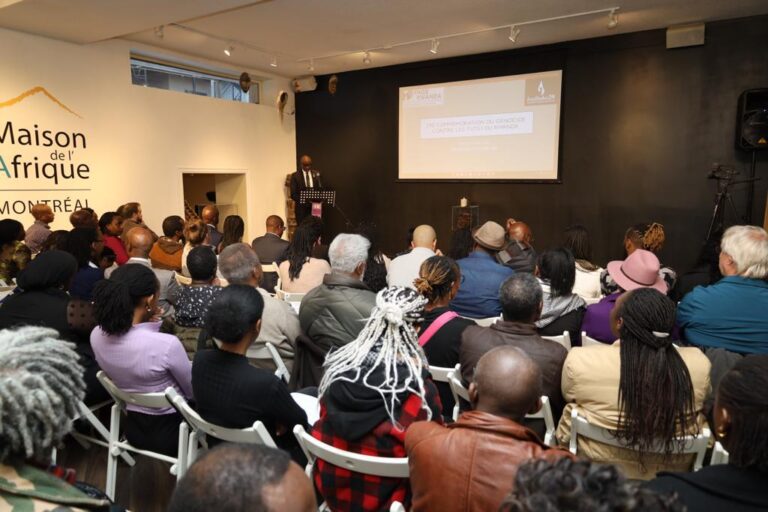 A group of people sitting in front of a projector screen.