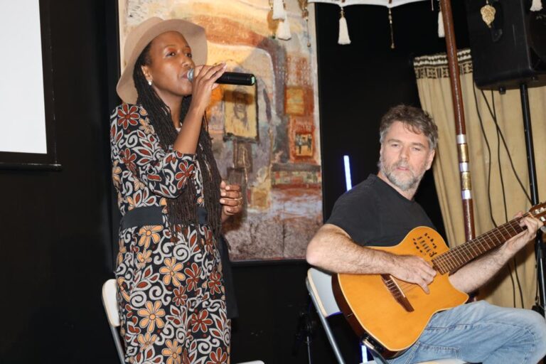 A woman and man singing into a microphone.