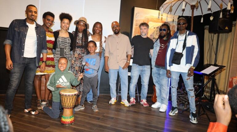 A group of people standing around a drum.