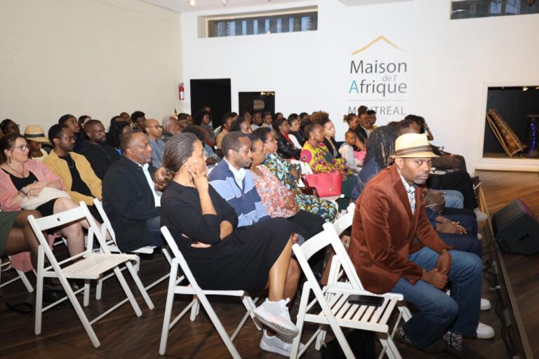 A group of people sitting in chairs at a gathering.