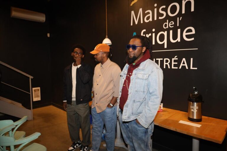 Three men standing in front of a wall.
