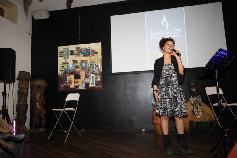 A woman standing in front of a projector screen.