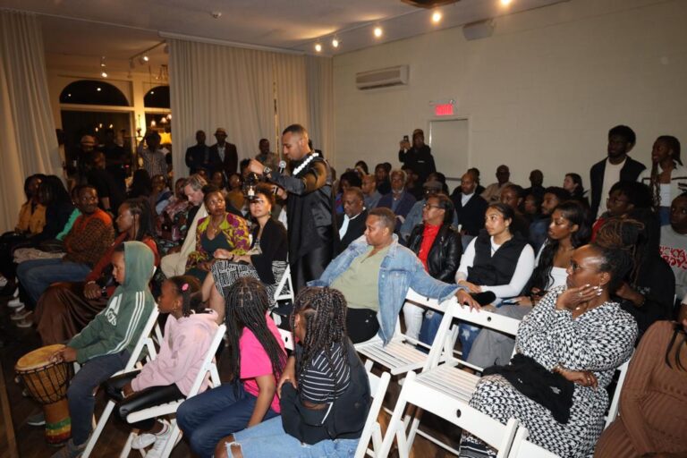 A crowd of people sitting in chairs and listening to an event.