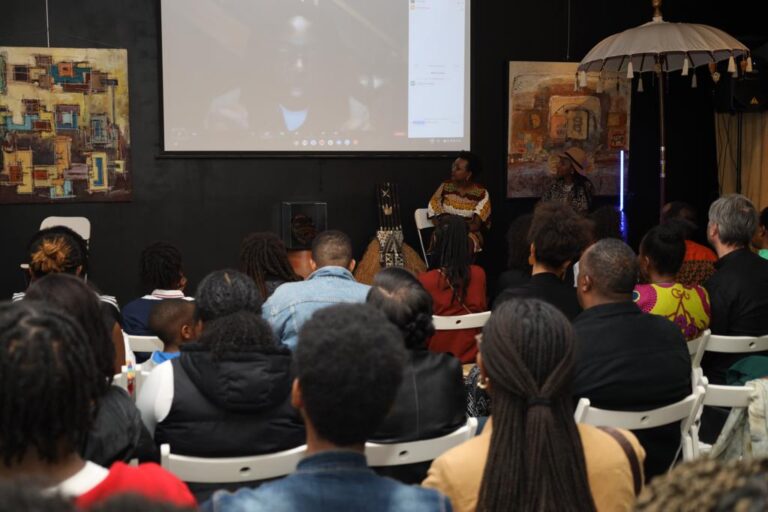 A group of people sitting in chairs watching an event.