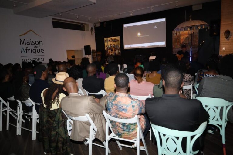 A group of people sitting in chairs watching a movie.