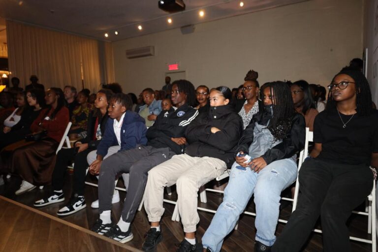 A group of people sitting in front of a crowd.