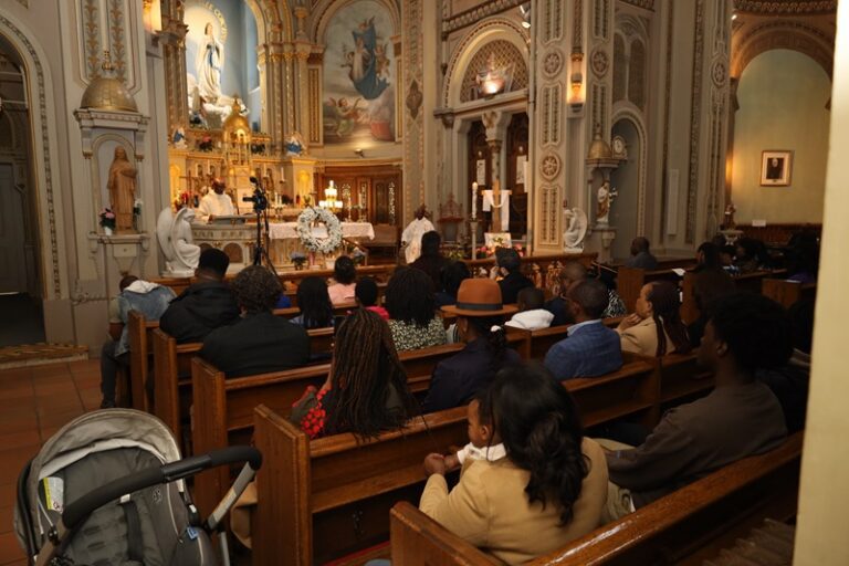 A group of people sitting in the middle of an aisle.