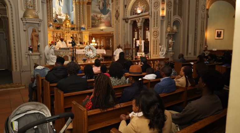 A group of people sitting in the middle of an aisle.