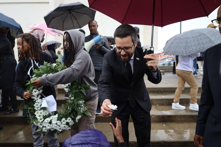A man in black suit holding an umbrella.