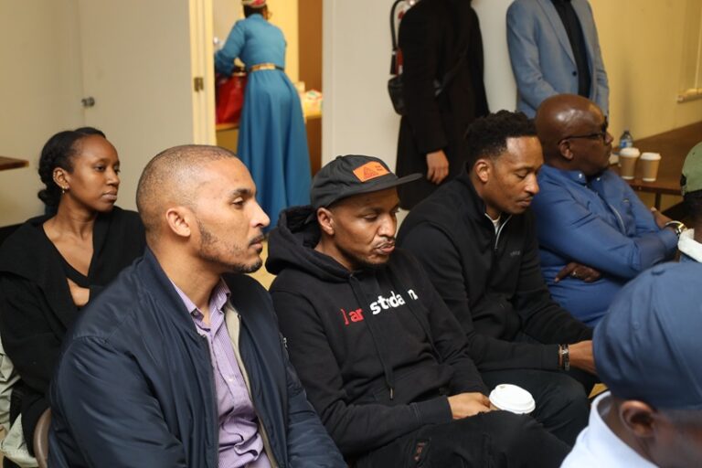 A group of men sitting in front of each other.