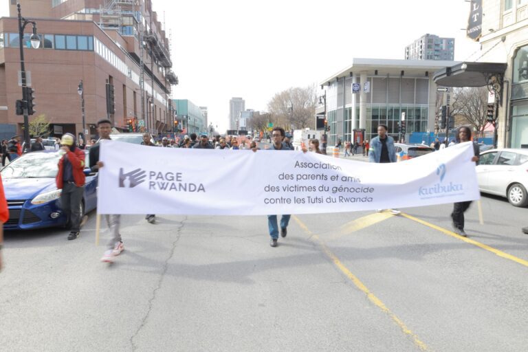 A group of people walking down the street holding up banners.