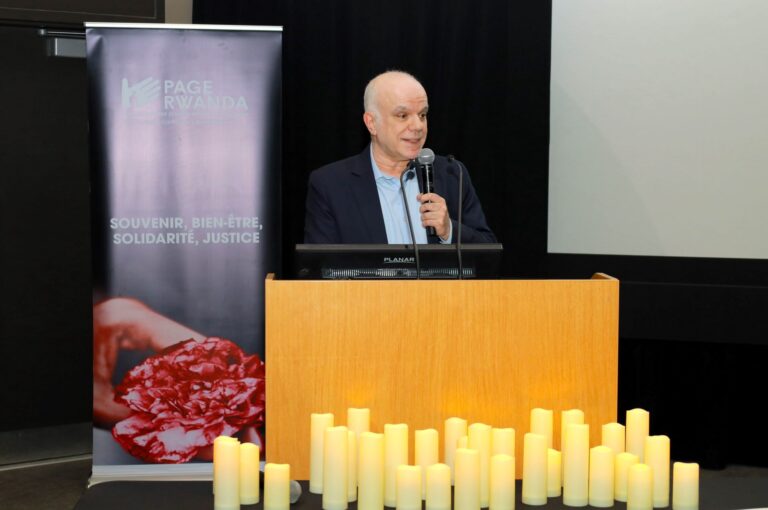 A man is speaking at a podium with candles.