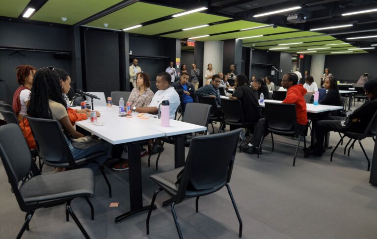 A group of people sitting at tables in an office.