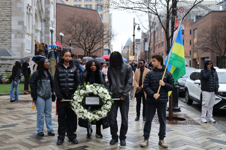 People holding wreath and flag in procession.