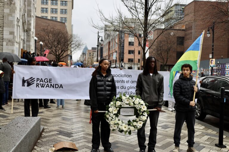 People holding wreath and flag at event.
