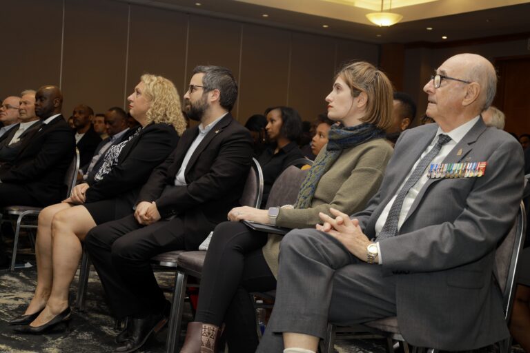 People seated attentively at an event.
