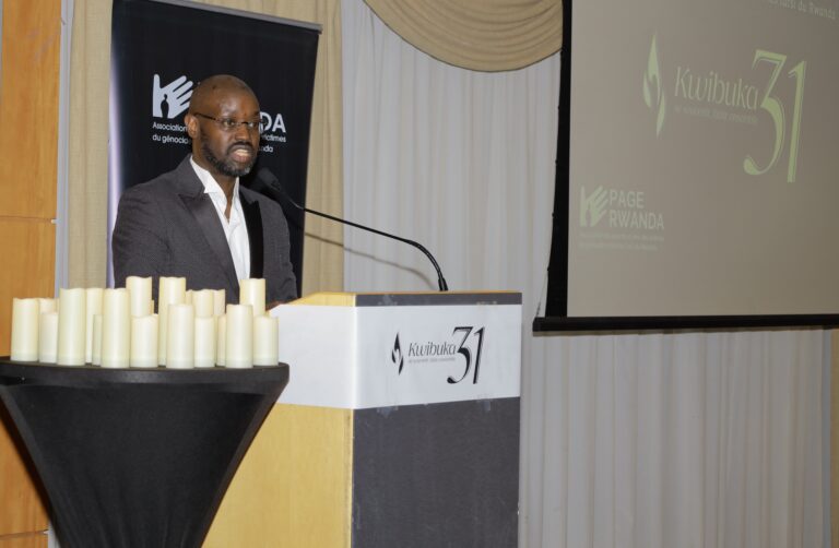 Man speaking at a podium with candles.