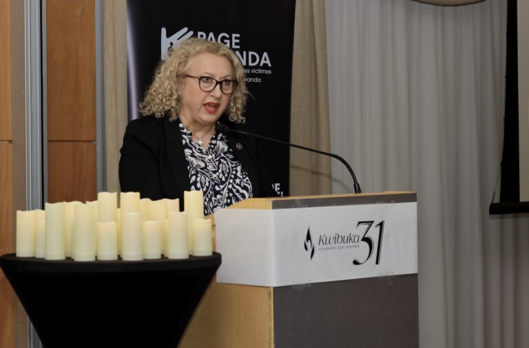 Woman speaking at a podium with candles.