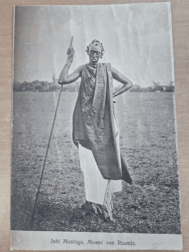 Person standing with a staff in field.